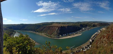 Panoramablick über die Rheinschleife mit den Orten an beiden Ufern unter blauem Himmel